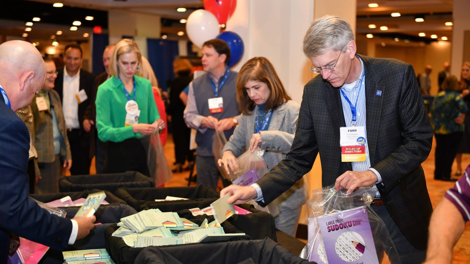 Attendees collecting books and coloring pencils for charity
