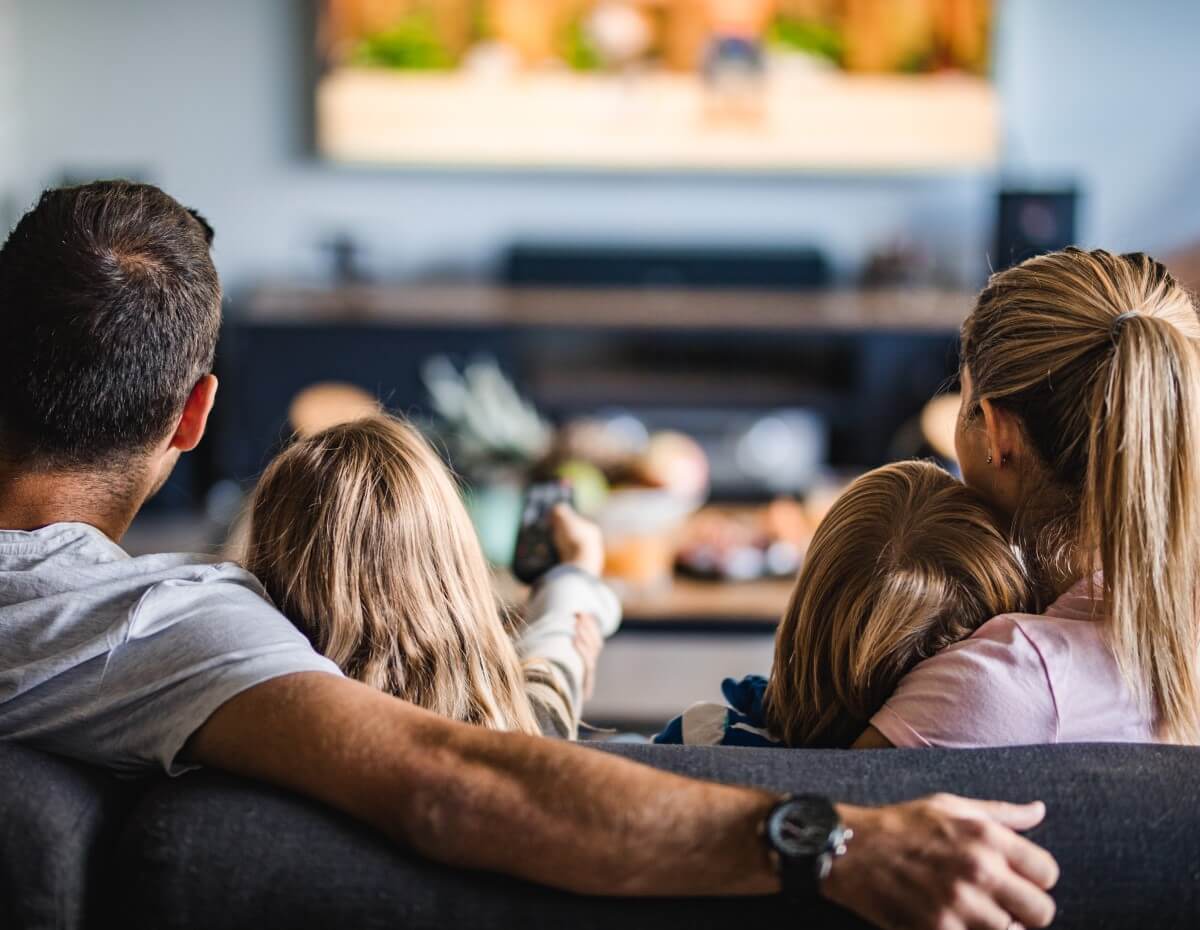 Family watching television in the living room