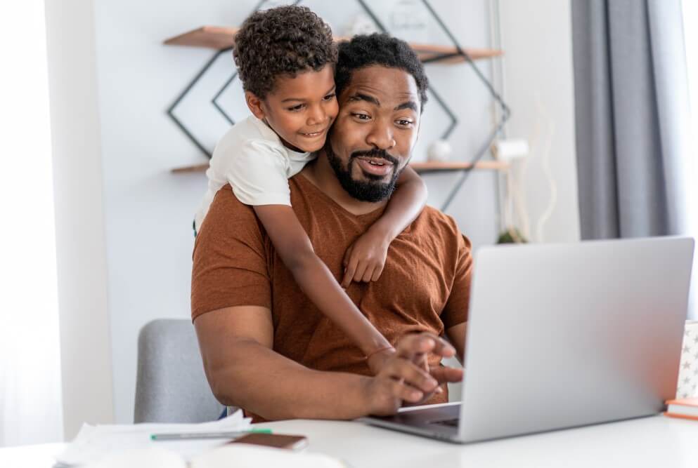 Father and son watching on a laptop in their house