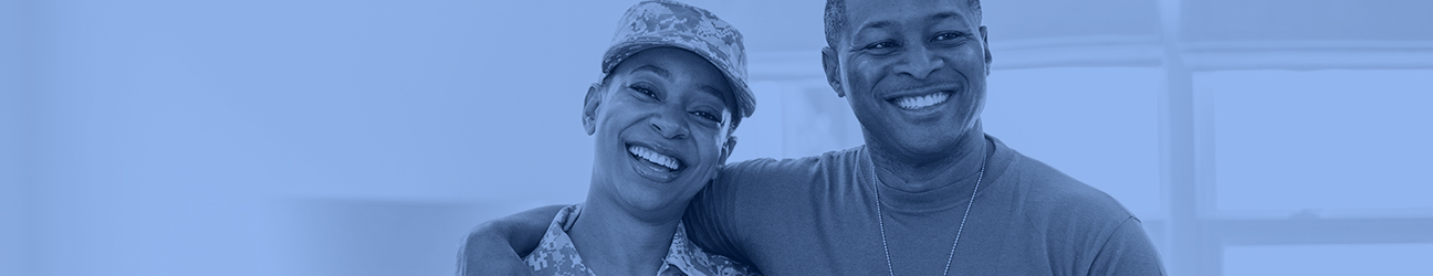 Two individuals smiling together in a military service or support