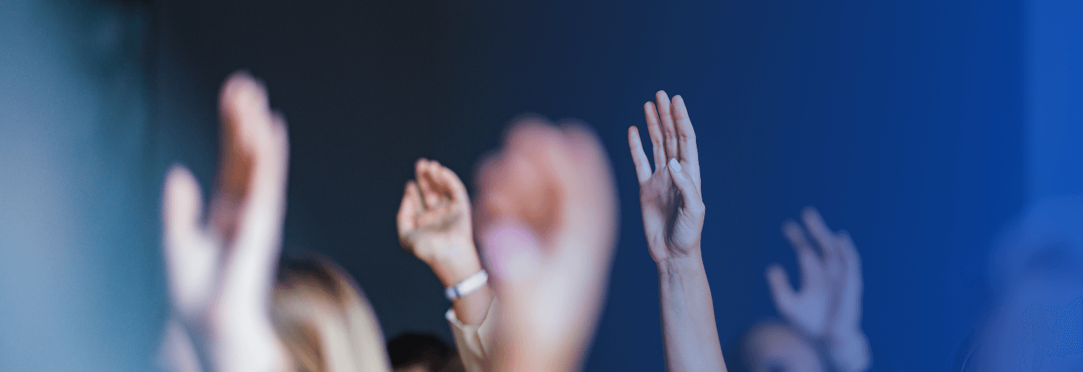 Picture of multiple people raising their hands
